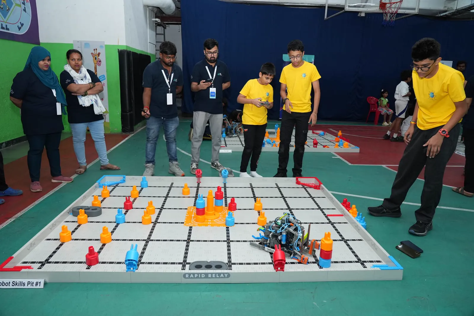 The competition arena at the VEX IQ India National Championship, teams and fields under the event lighting