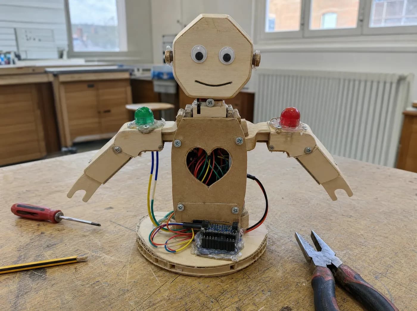 Meher, with Good Touch & Bad Touch. A friendly wooden teaching figure with a green light glowing on one shoulder and a red light on the other, wired to touch sensors