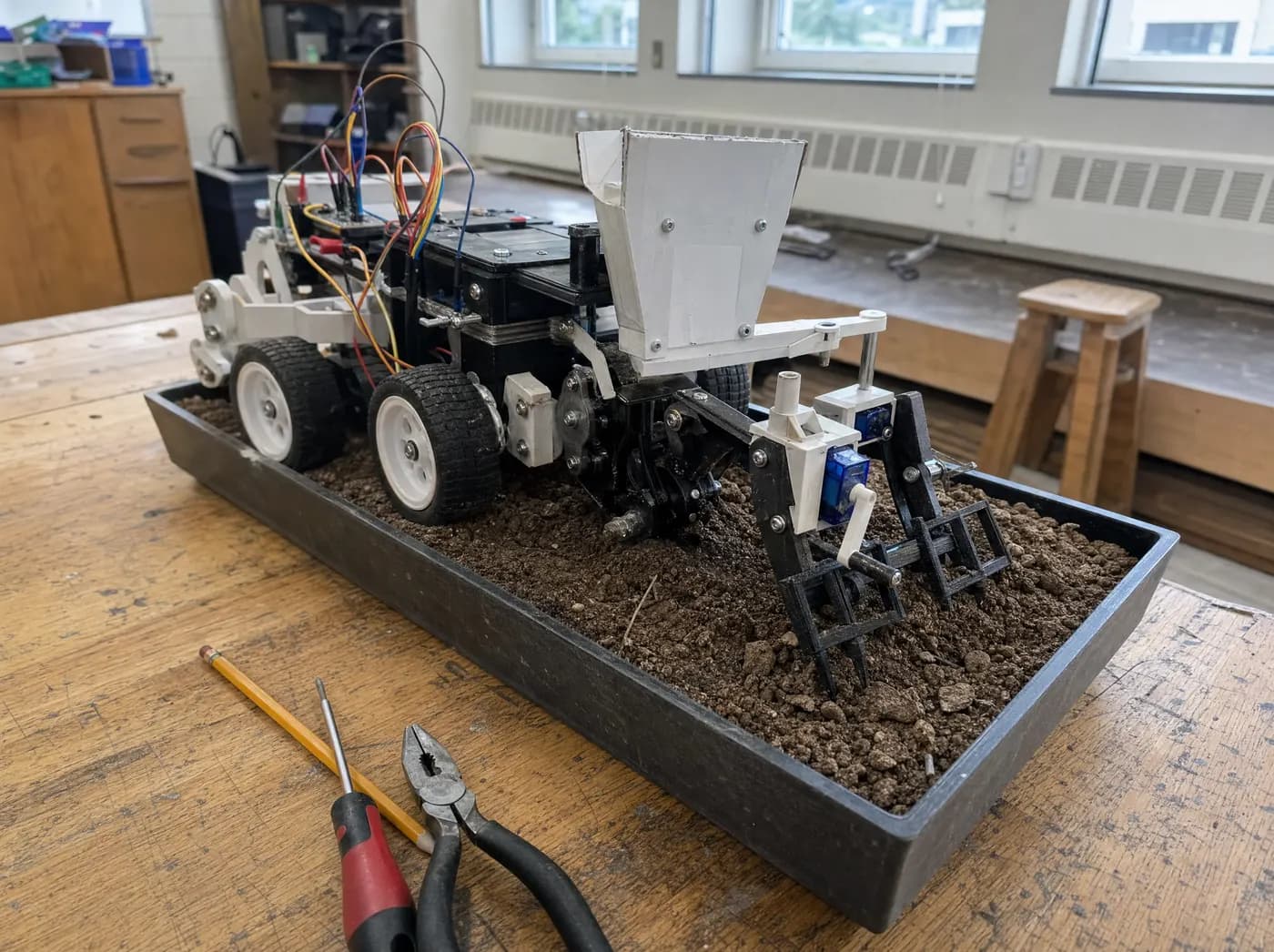 Dev, with Agromate. A compact wheeled farm machine with interchangeable attachments in a soil tray