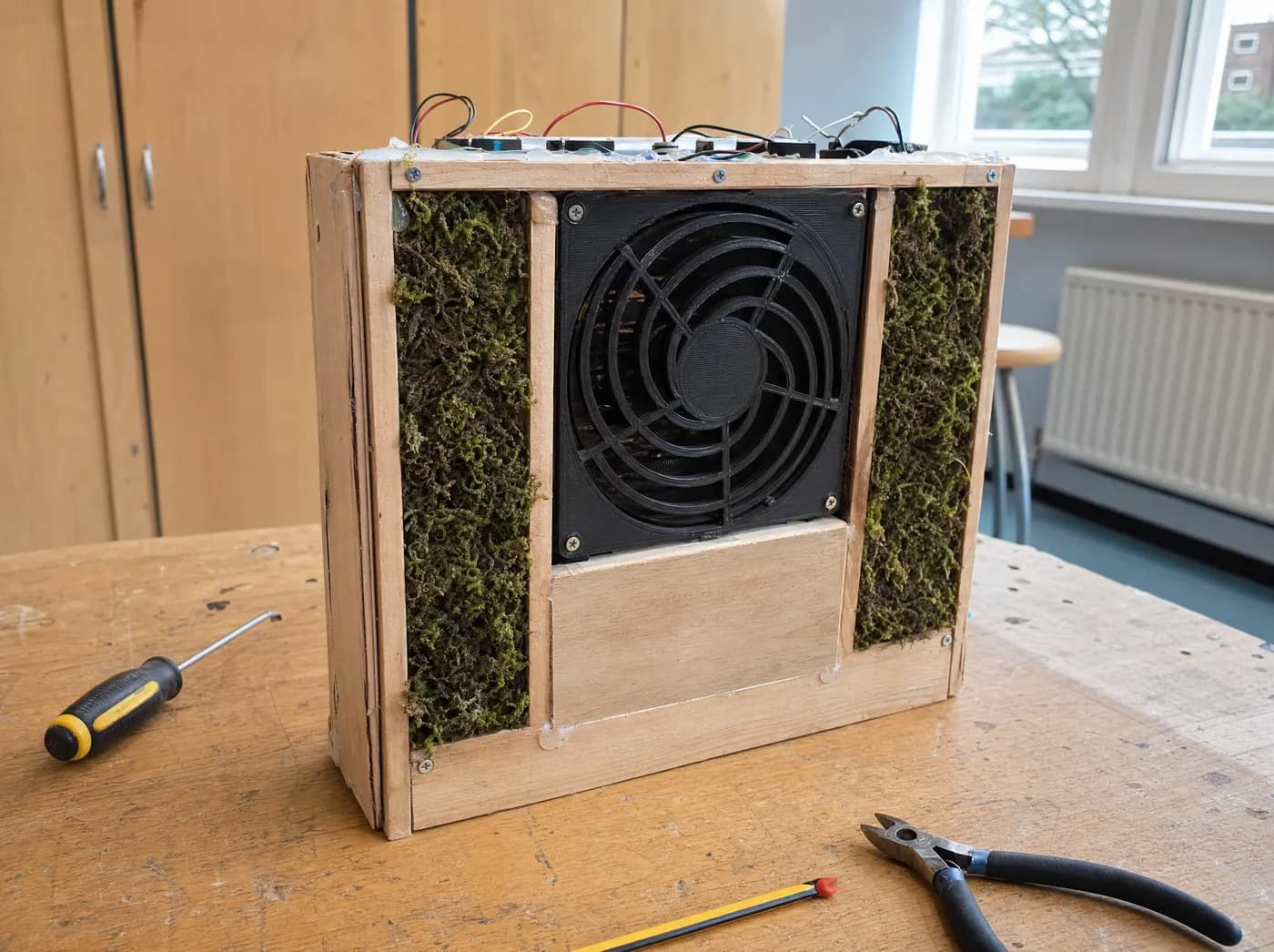 Kiara, with Bio Breathe. A wooden air purifier with living moss panels and a quiet fan grille