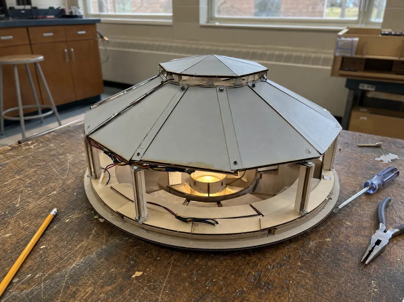 Yash, with Circle. A community pavilion model with ring-shaped seating around a warm lit centre