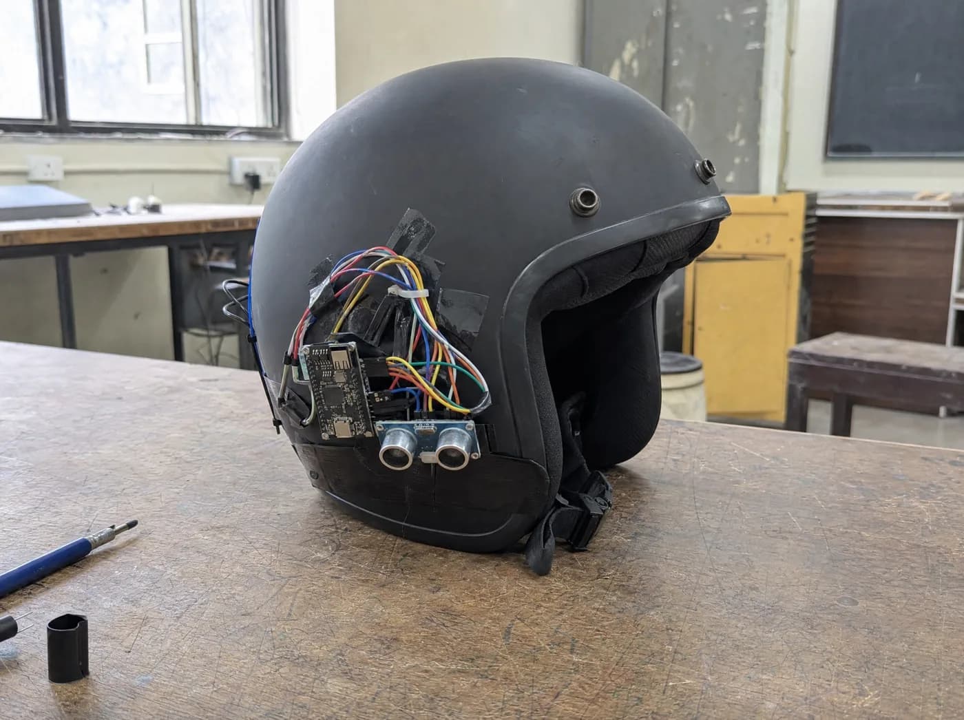 Sia, with KavacH. A smart helmet with a sensor module resting on a scooter seat