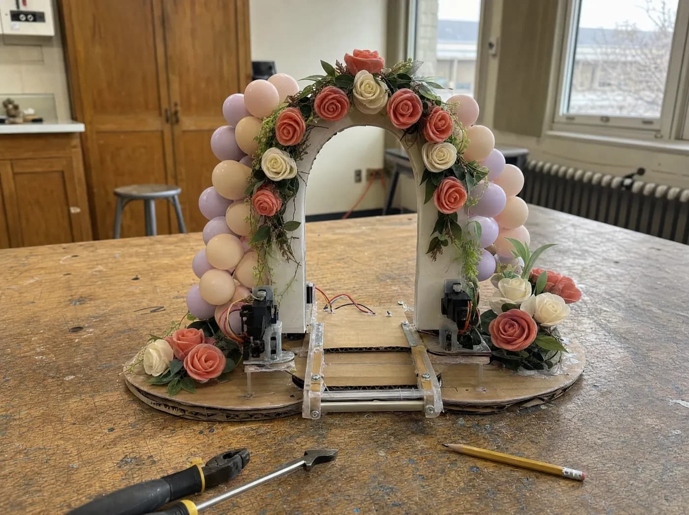 Mishka, with Rose Aura. Rose arrangements and pastel balloon clusters around a decorated arch model