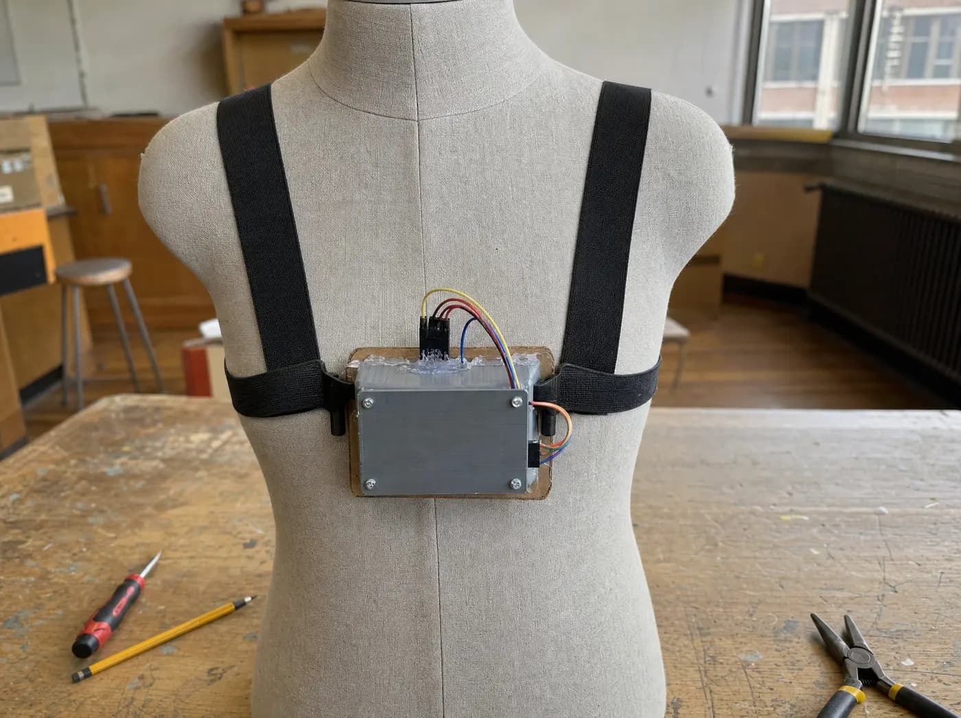 Om, with Spine-O-Guard. A fabric posture band with a small electronics pod on a mannequin torso